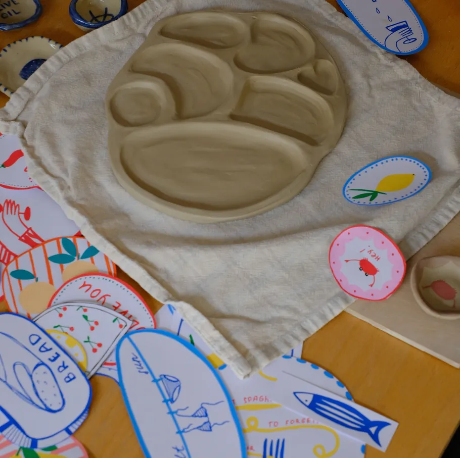 Clay plate on cloth surrounded by colorful cards.