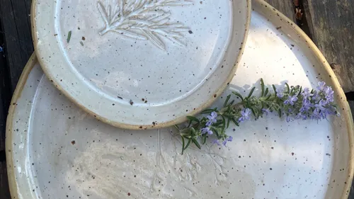 Two ceramic plates with rosemary design.