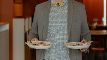 Person holding two plates in a restaurant.