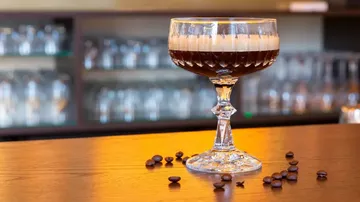 Cocktail glass with coffee drink on bar.