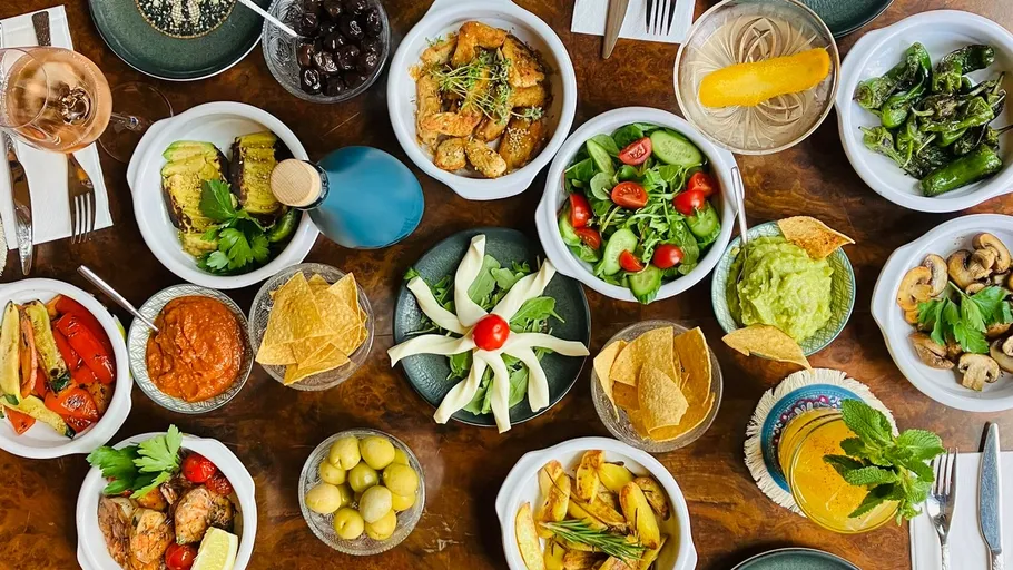 Various dishes and drinks on a wooden table.
