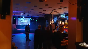 People socializing in a dimly lit bar.