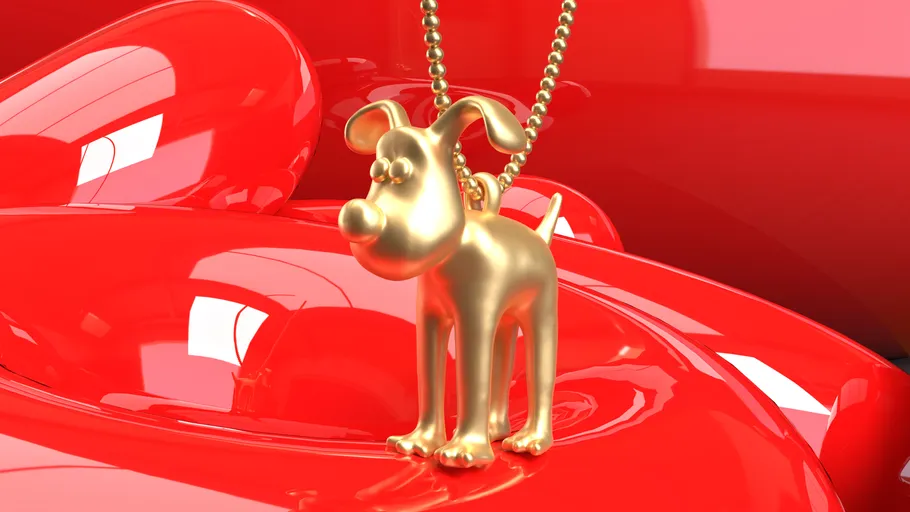 Gold dog necklace on shiny red surface.
