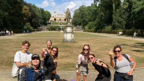 People posing in a park, statue in background.
