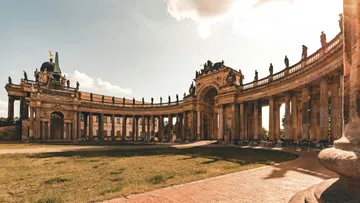Grand colonnade in ornate architectural courtyard.