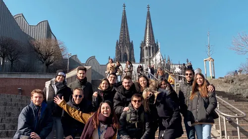 Group of people posing near cathedral steps.
