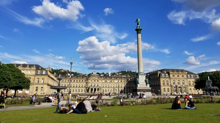 Menschen entspannen vor historischem Gebäude.