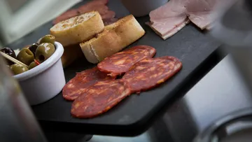 Charcuterie board with meats, olives, and bread.