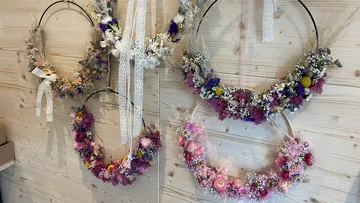 Floral wreaths hanging on a wooden wall.