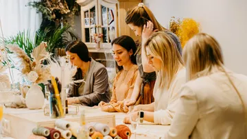 Five women crafting at a decorated table.