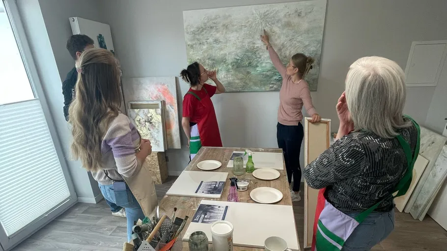 Gruppe betrachtet Gemälde in Kunstkursstudio