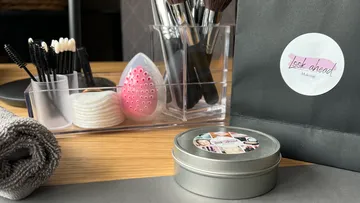 Make-up-Pinsel und -Werkzeuge auf Holztisch.