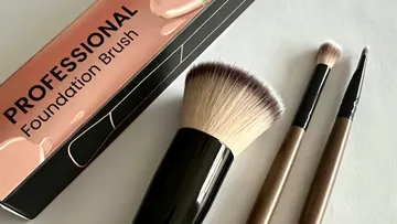 Make-up-Pinsel neben Produktverpackung.