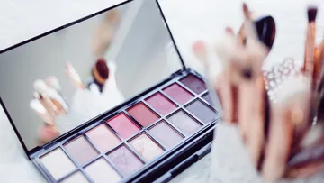 Make-up-Palette und Pinsel auf Tisch.