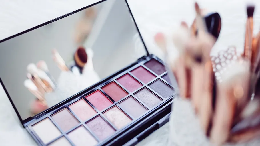 Makeup palette and brushes on table.