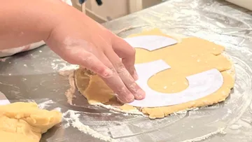 Hand formt Teig mit Papierschablone.
