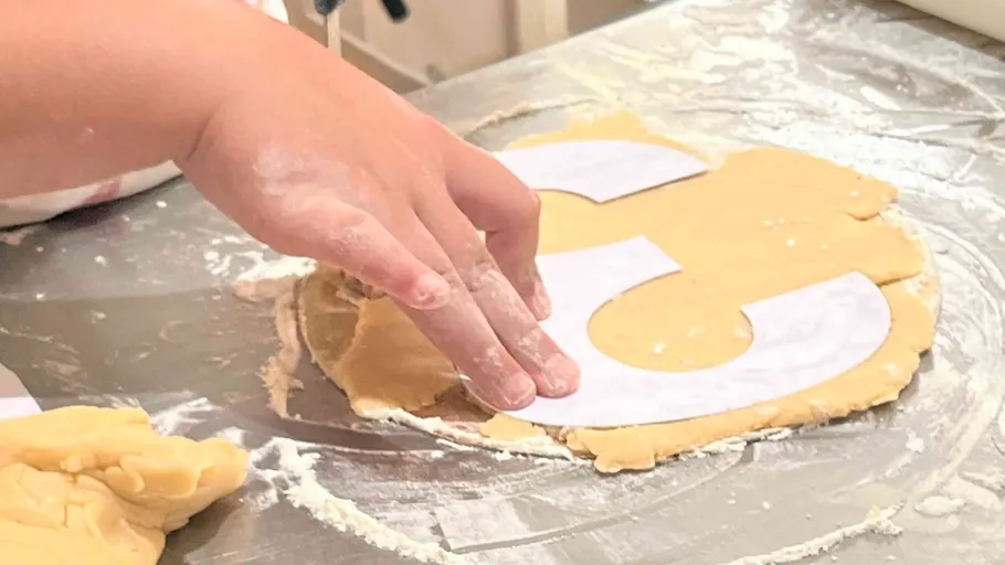 Hand shaping dough with paper template.