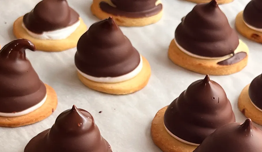 Chocolate-covered cookies on white parchment paper.