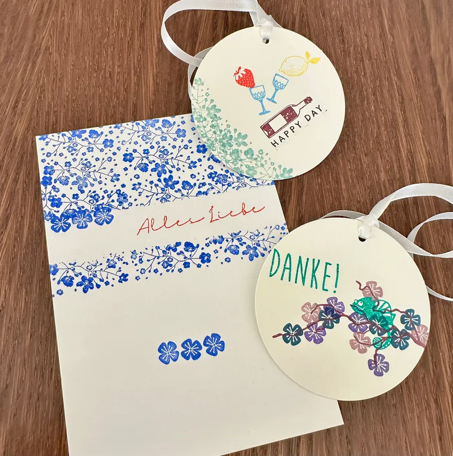 Blumige Karte und Anhänger auf Holztisch.