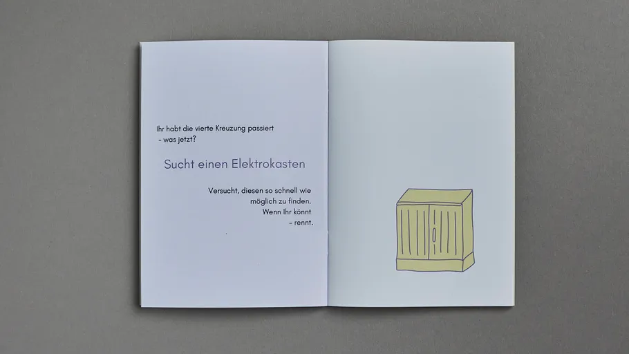 Open book with text and illustration, on gray surface.