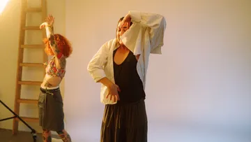 Two people dancing in a studio setting.