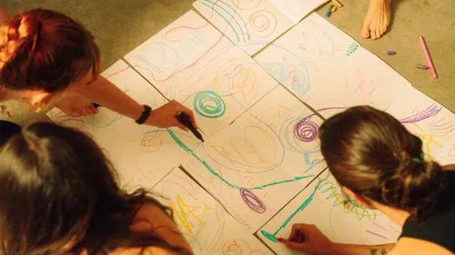 People drawing colorful patterns on paper.