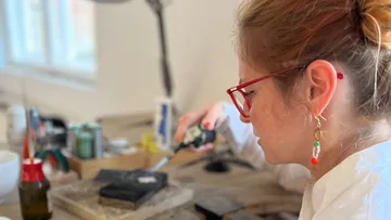 Frau arbeitet mit Werkzeug in Werkstatt.