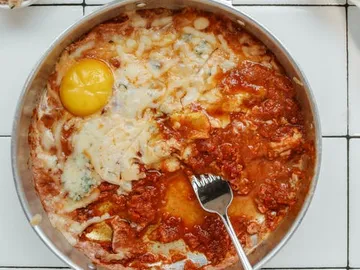 Eier und Käse in einer Sauce in einer Pfanne.