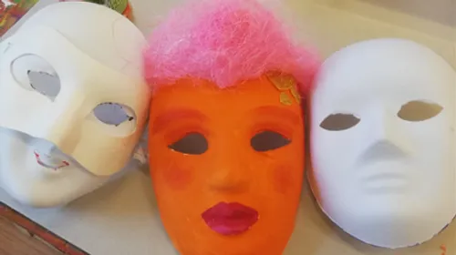 Three painted masks on a surface.