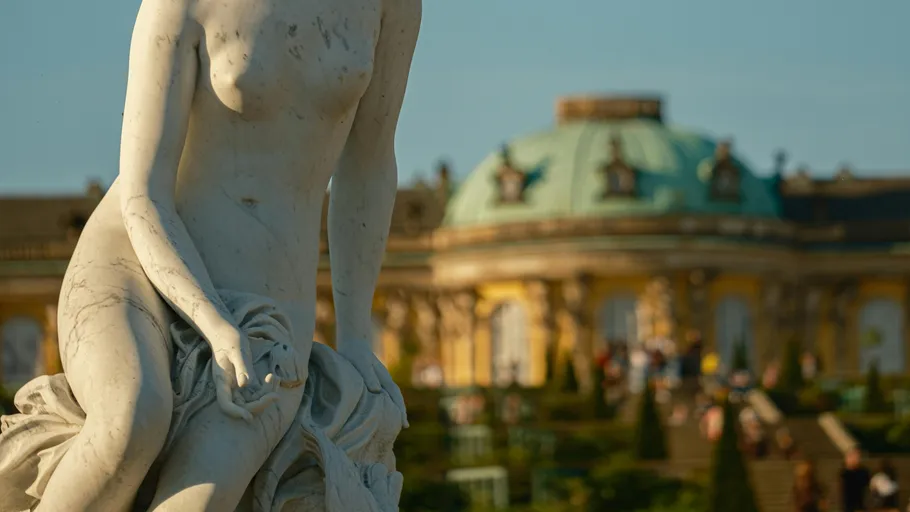 Statue in foreground, palace in background.