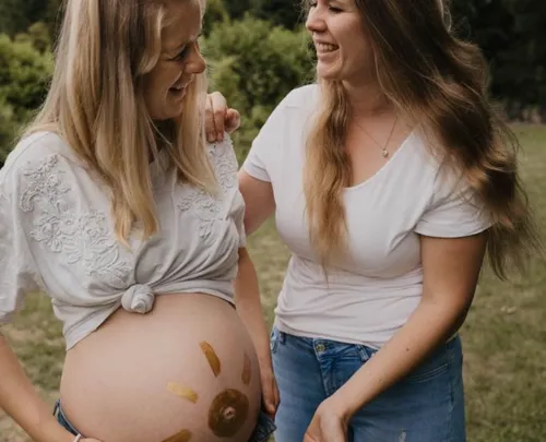 Zwei lachende Frauen im Freien, eine schwanger mit Bauchkunst.