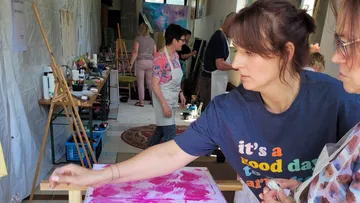 Frau malt in Kunststudio mit anderen.