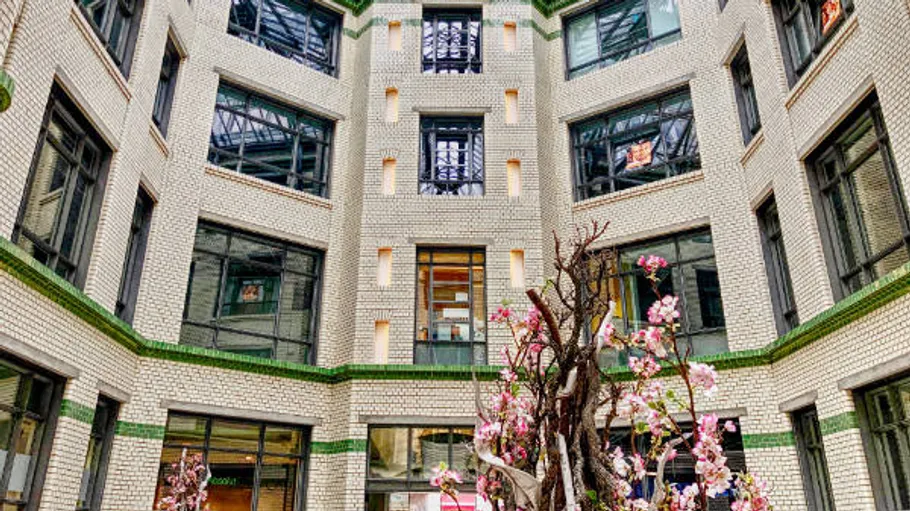 Brick atrium with windows and blossom tree.