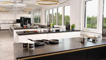 Modern kitchen with large windows and cooking islands.