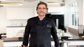 Chef smiling in a modern kitchen.