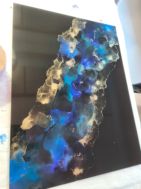 Abstract painting with blue and gold swirls.