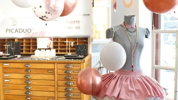 Jewelry display with pink dress mannequin.