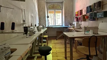 Sewing machines in a narrow, well-lit room.
