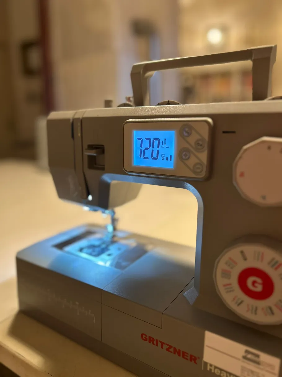 Nähmaschine mit digitalem Display im Raum.