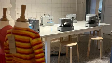 Nähmaschinen auf Tisch in Werkstatt.