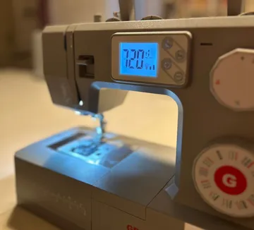 Sewing machine with digital display in room.