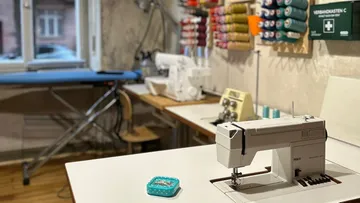 Nähmaschine auf Tisch in Werkstatt.