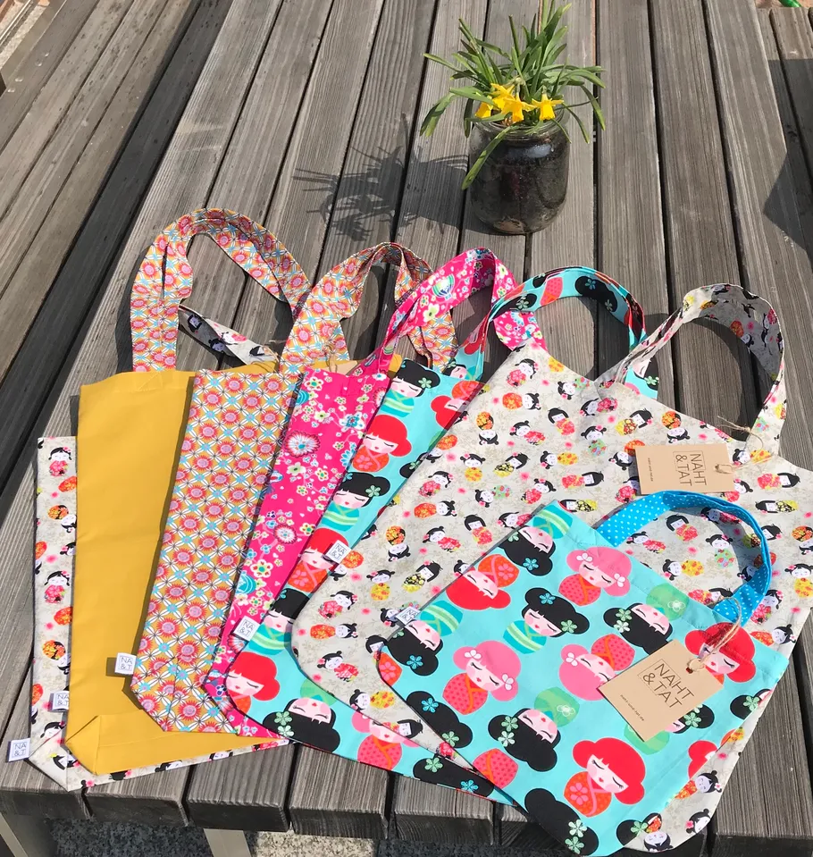 Colorful tote bags on a wooden table.