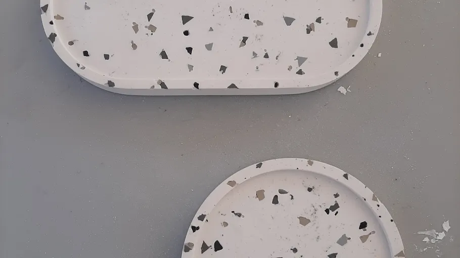 Terrazzo trays with speckled pattern on gray surface.