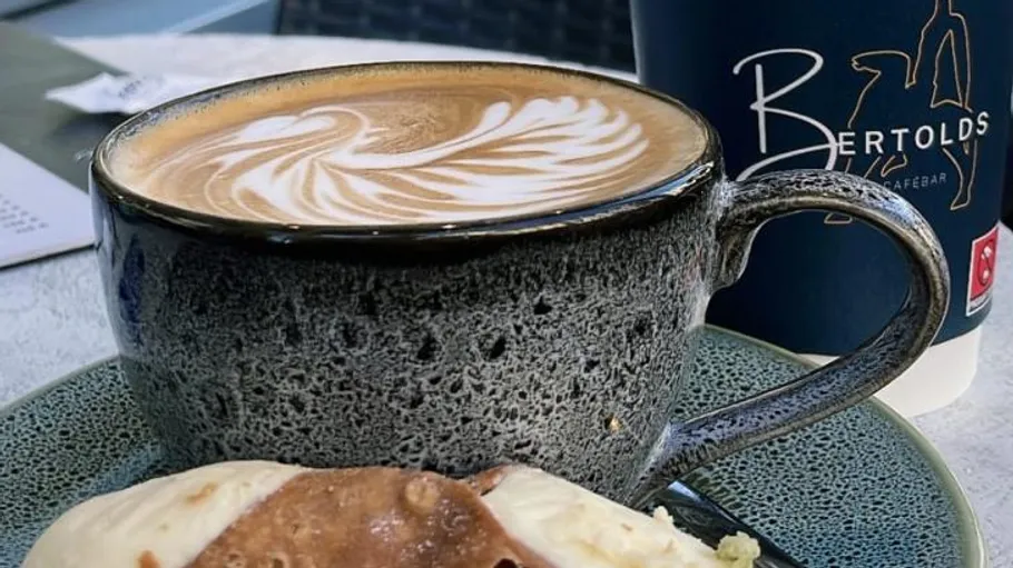 Coffee cup with latte art on table.