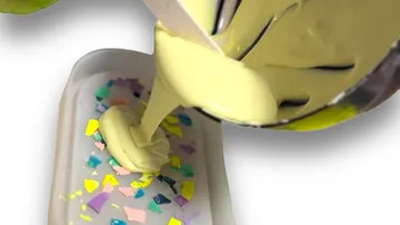 Yellow batter poured into a colorful mold.