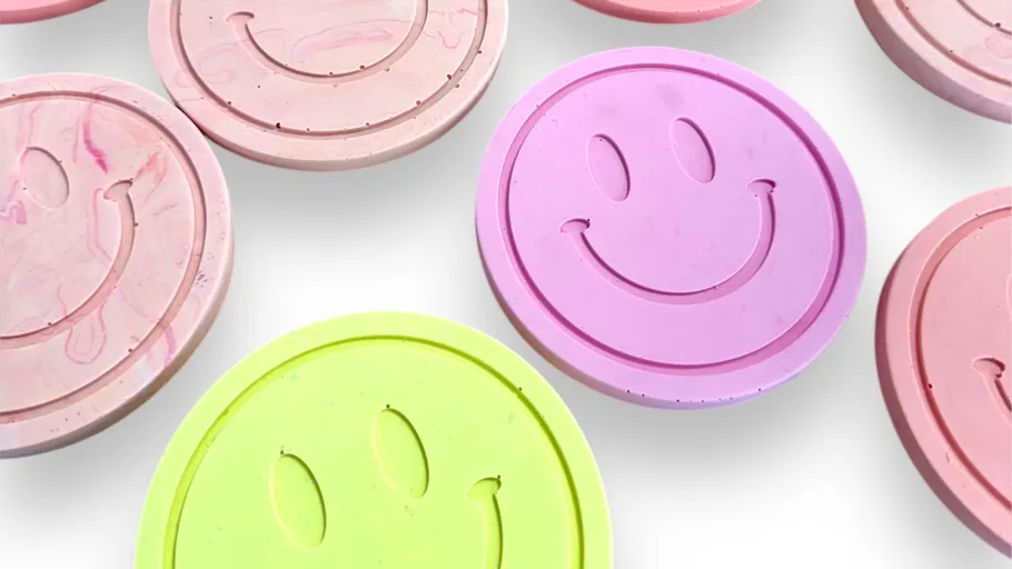 Colorful smiley face coasters on white background.
