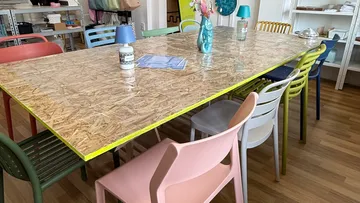 Holztisch mit bunten Stühlen im Büro.