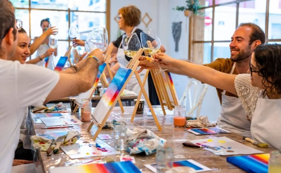 Menschen stoßen mit Wein in Kunstklasse an.