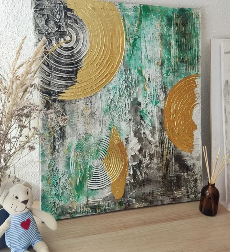 Abstract painting with gold circles on table.